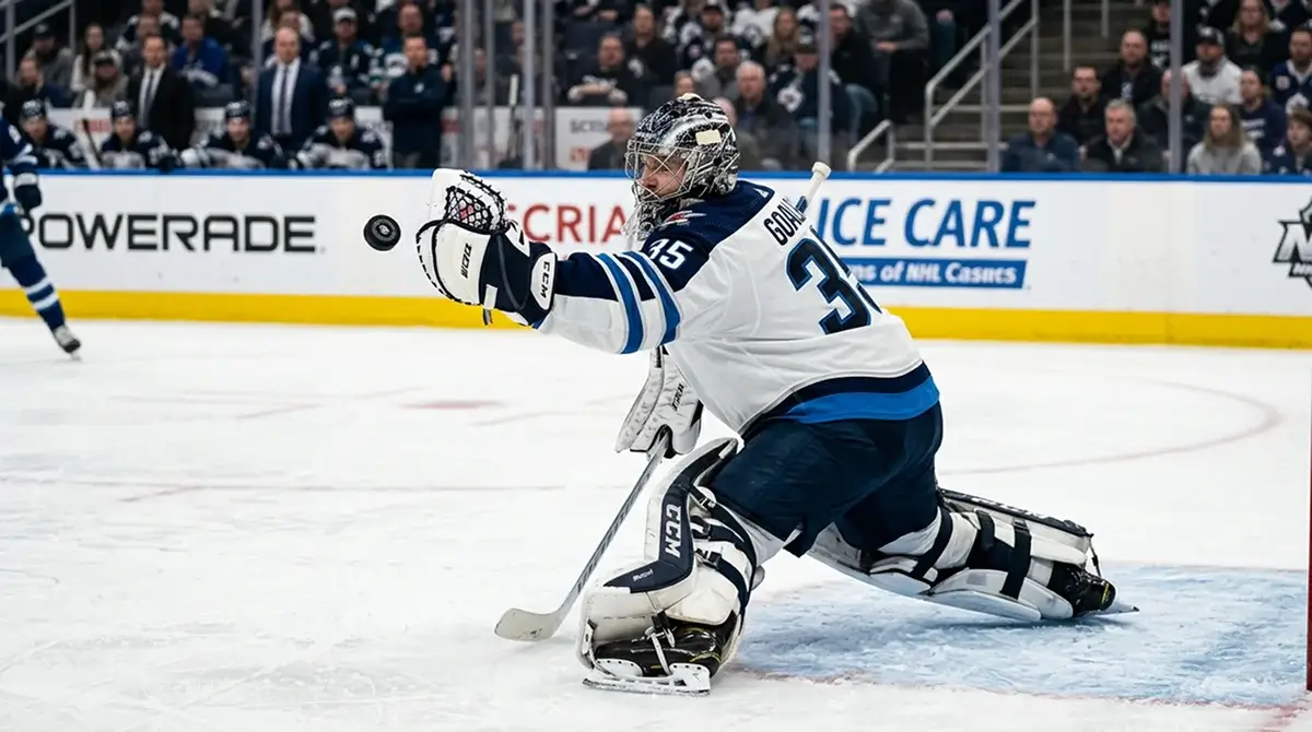 NHL goaltender making a glove save with trapper extended toward an incoming shot