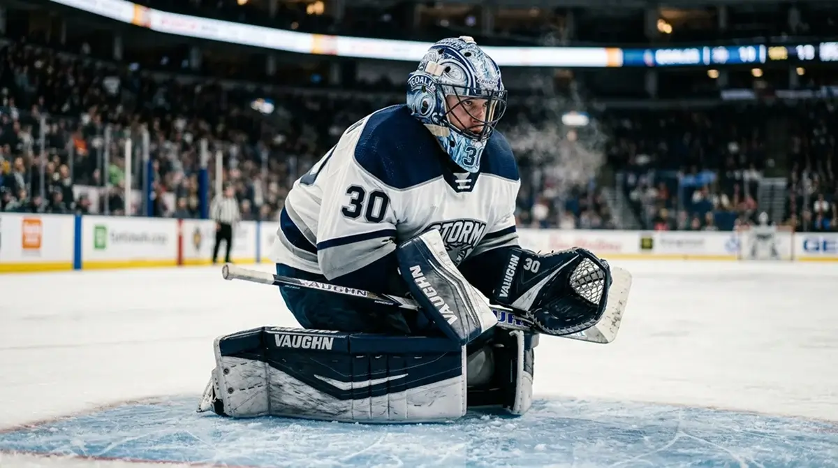 NHL goaltender in mask and pads kneeling on the crease before puck drop