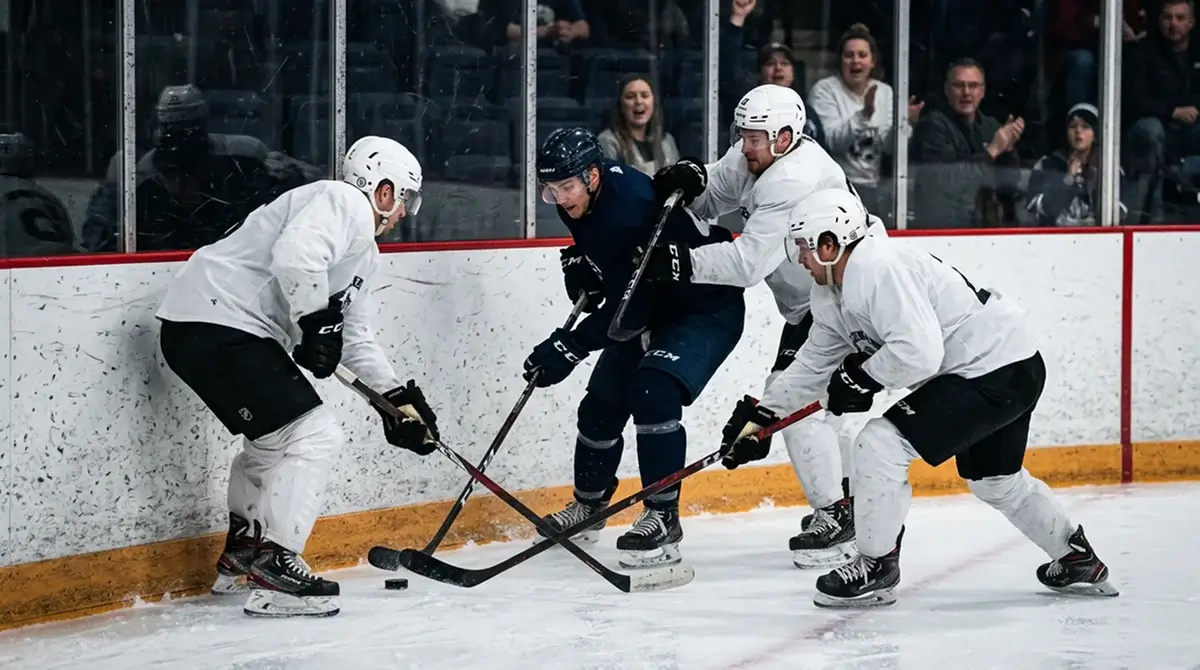 NHL defensive zone coverage with three defenders pressuring a puck carrier near the boards