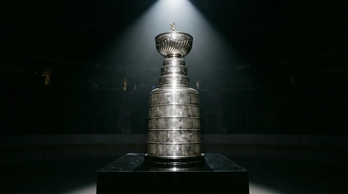 Stanley Cup trophy displayed on pedestal under arena spotlights ahead of NHL futures